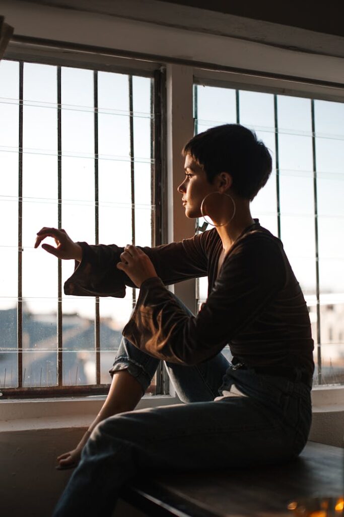 Tranquil woman sitting in solitude near window